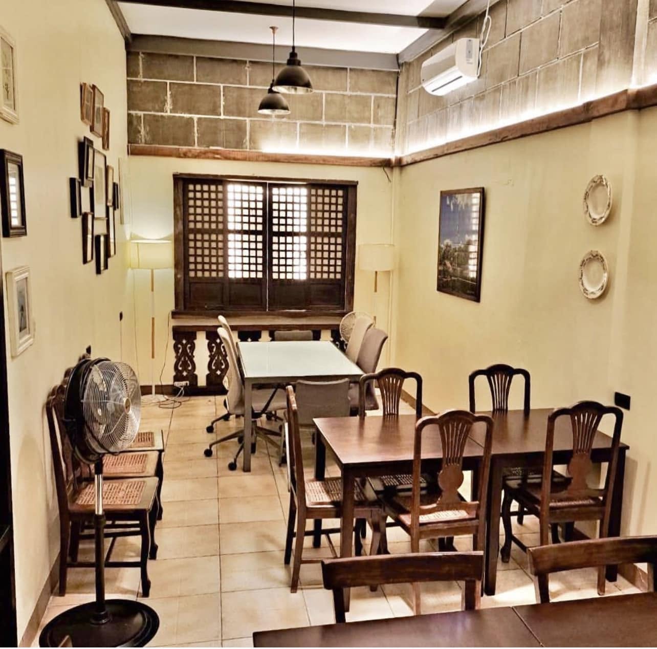 Celestino's dining room with capiz-shell windows, stone walls, and dark wooden furniture